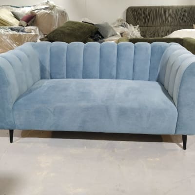 ספה מרופדת בכחול עם רגליים שחורות
