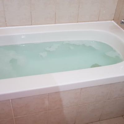 אמבטיה מלאה במים עם קצף קל על הקרמיקה