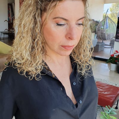 אישה עם שיער מתולתל ואיפור עדין