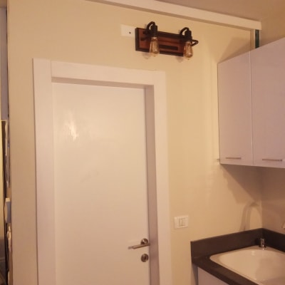 מנורת קיר עם שתי נורות חשמליות מעל דלת