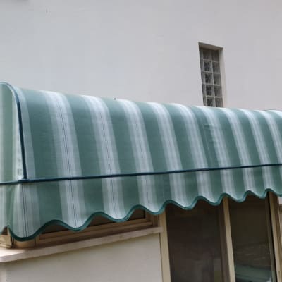 סוכך ירוק מפוספס מותקן מעל חלון