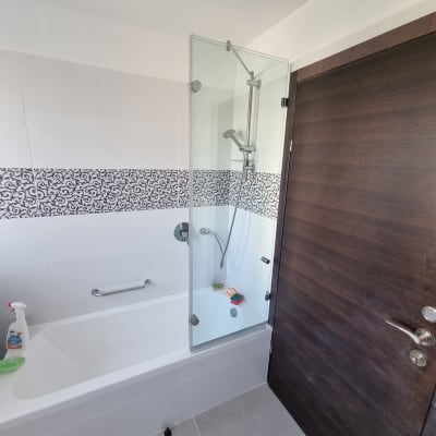 מקלחת עם דלת זכוכית, ראש מקלחת ומוצרים לניקוי