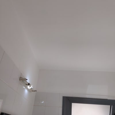 קיר צבוע בלבן עם תאורה עליונה