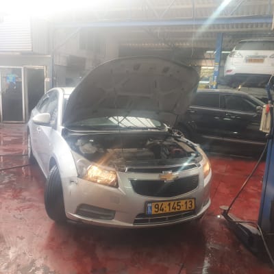 רכב עם מכסה מנוע פתוח במוסך