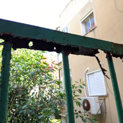 מעקה מתכת חלוד עם חורים ושברים