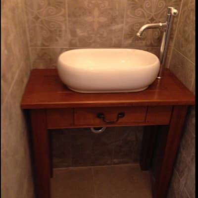 כיור מונח על שולחן עץ עם ברז מתכת