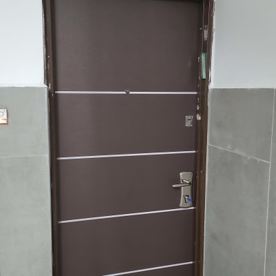 דלת חומה עם ידית כסופה ומסגרת מתכת