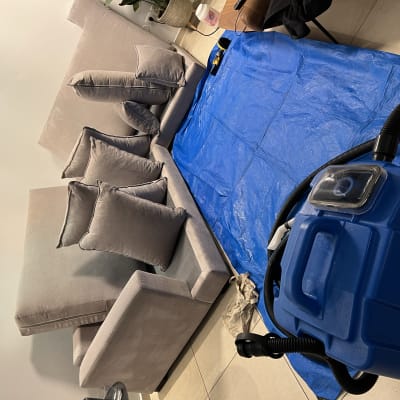 מכונת ניקוי כחולה ליד ספה וכיסוי כחול