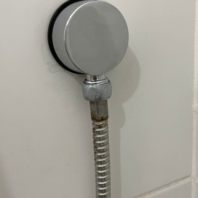 צינור מתכת מחובר לקיר עם חיבור עגול