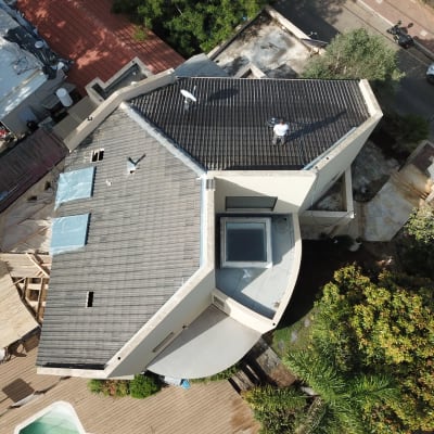 גג עם אדם עובד, אנטנה ופתחים מכוסים בניילון