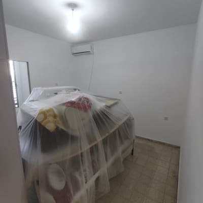 חדר עם רהיטים מכוסים בניילון לקראת צביעה