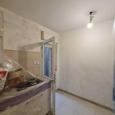 קיר צבוע חלקית עם סימני צבע, נורה תלויה