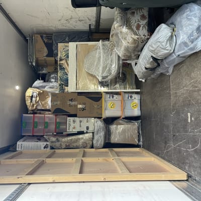 ארגזים ופריטים עטופים בניילון בתוך משאית הובלה