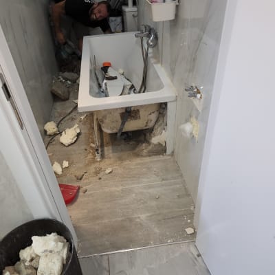 אינסטלטור עובד על תיקון אמבטיה עם כלים