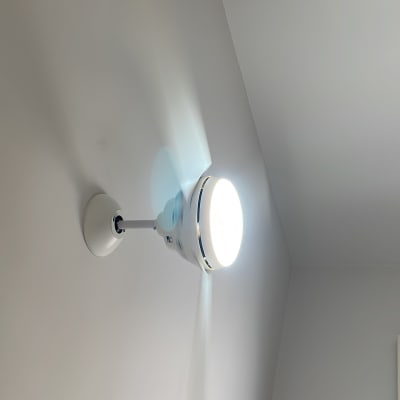 מנורת קיר עגולה מוארת על תקרה לבנה