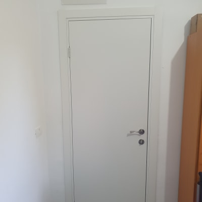דלת לבנה עם ידית מתכת בחדר פנימי