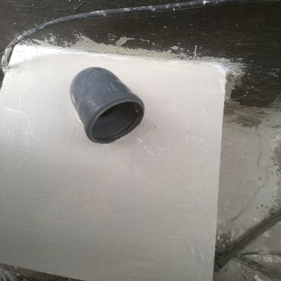 צינור גומי שחור על משטח לבן עם חומר איטום