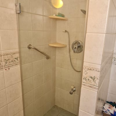 מקלחת עם דלת זכוכית, מדפים וברזים