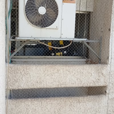 רשת מתכת סביב מזגן למניעת כניסת יונים