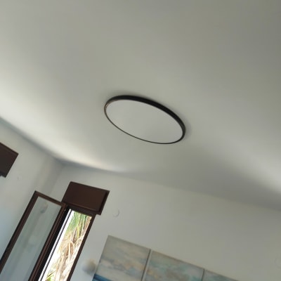 תאורה עגולה בתקרה וסולם עץ בחדר