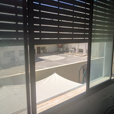 חלון אלומיניום עם תריסים פתוחים למחצה