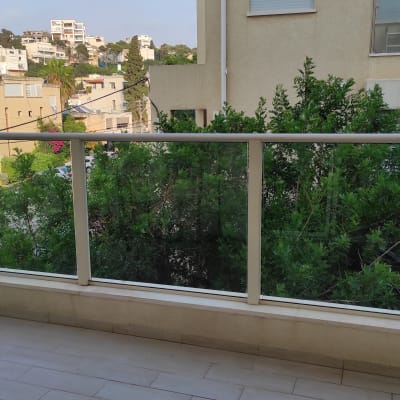 מרפסת עם רצפה נקייה ומעקה זכוכית