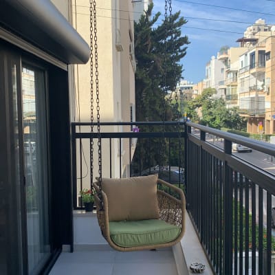 נדנדה תלויה בשרשראות על מרפסת