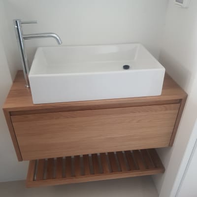 כיור מלבני עם ברז כרום על ארון עץ