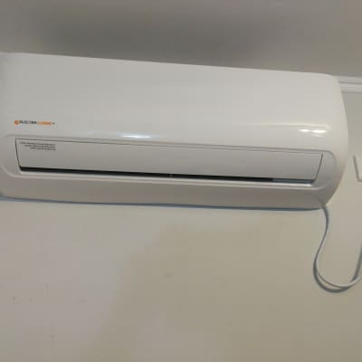 מזגן קיר לבן עם כבל חשמל מחובר