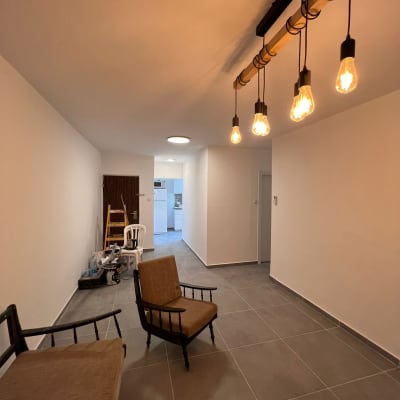 סולם, כיסאות וכלי עבודה בחדר משופץ