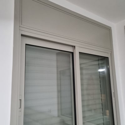 חלון עם תריסים סגורים במסגרת לבנה