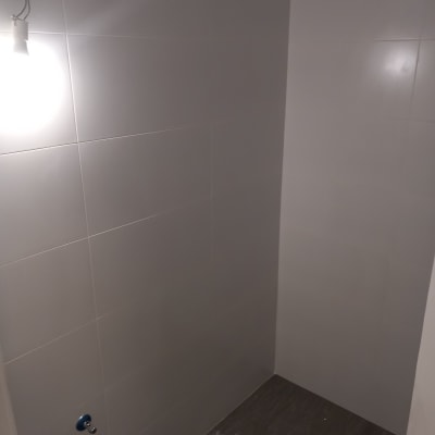 קיר אריחים לבנים עם חיבורים לצנרת