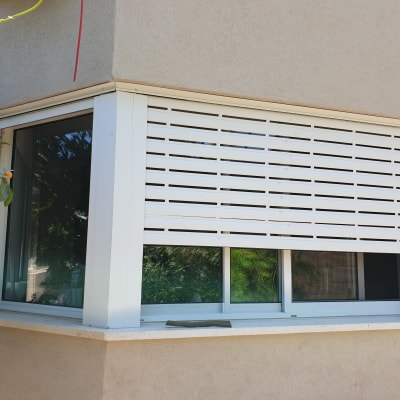 חלון אלומיניום עם תריסים לבנים חיצוניים