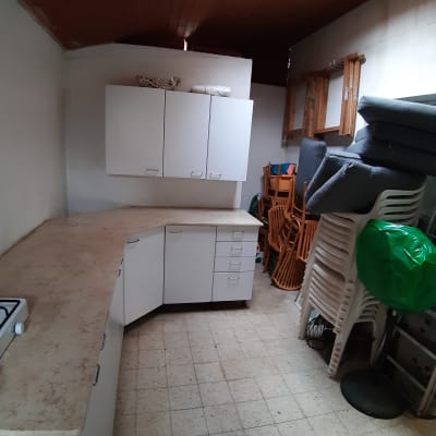 ארונות לבנים, כיסאות נערמים, כריות, חלון גג