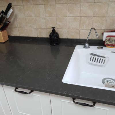 משטח שיש כהה ליד כיור במטבח