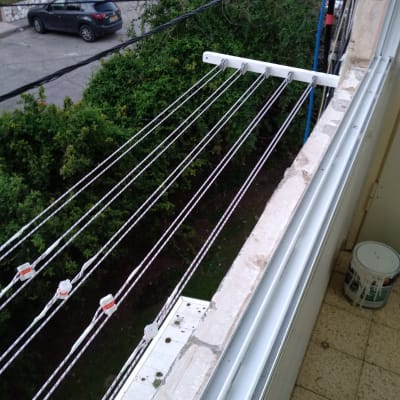 חבלי כביסה מותקנים על מתקן חיצוני במרפסת
