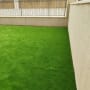 דשא ירוק מלאכותי בחצר מגודרת