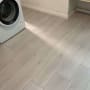 רצפת פרקט עץ בהירה ליד מכונת כביסה