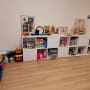 מדפים לבנים עם צעצועים, ספרים ומשחקים מאורגנים