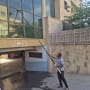 אדם מנקה חלונות גבוהים עם מוט ארוך