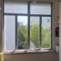 חלון אלומיניום עם נוף לעצים ובניינים
