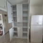 ארון פתוח עם מדפים ודלתות במטבח