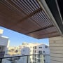 פרגולה מאלומיניום במרפסת עם נוף לבניינים