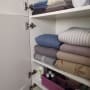 ארון מסודר עם מגבות ומצעים מקופלים