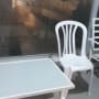 כיסא פלסטיק לבן ושולחן במרפסת