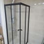 מקלחון זכוכית עם מסגרת שחורה וברז מקלחת