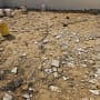 שברי אריחים וכלי עבודה על רצפת חול באתר שיפוץ