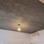 תקרת בטון חשופה עם נורה תלויה