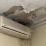 תקרה מתקלפת עם סימני רטיבות מעל מזגן