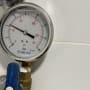 מד לחץ עם ברז כחול וצינור מתכת